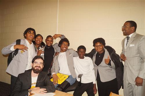 **Alt Text:** A group photo of the Henry Ford High School Debate Team standing together indoors after winning the 2025 Umoja 